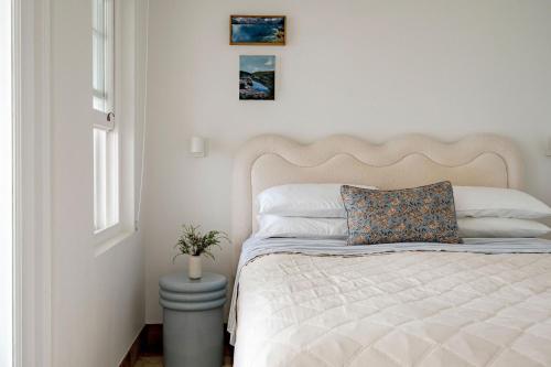 a bedroom with a bed with a pillow and a window at Fogo @ Ethel & Ode’s in Bundeena