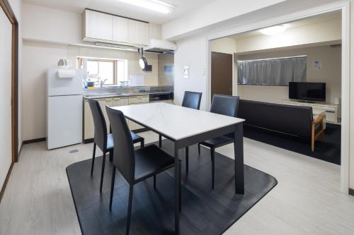 a kitchen and dining room with a table and chairs at マンションメゾンV206 maisonV206 in Gifu