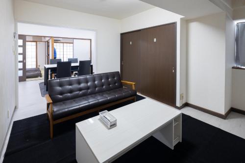 a living room with a couch and a table at マンションメゾンV206 maisonV206 in Gifu
