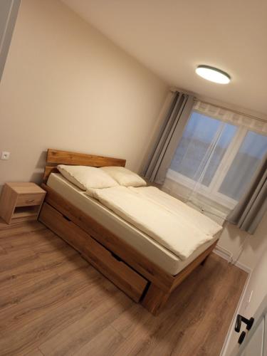 a bedroom with a bed and a window at Apartmán s 2 spálňami in Prievidza