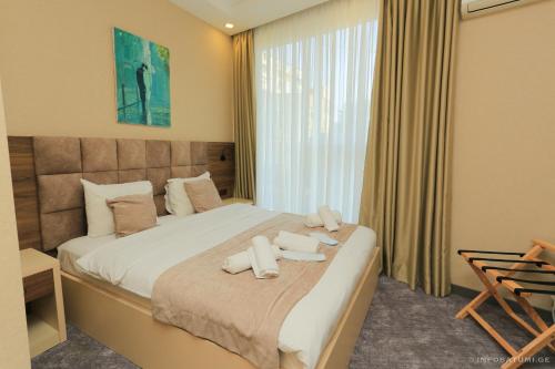 a bedroom with a bed with two towels on it at Aniko Hotel in Batumi