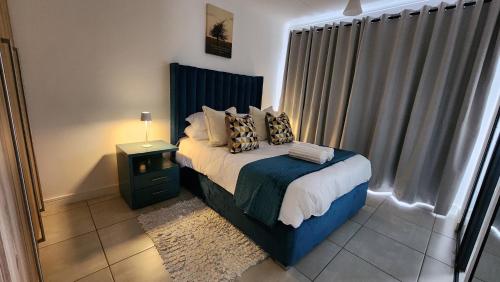 White House At The Blyde Crystal Lagoon في بريتوريا: غرفة نوم عليها سرير ومخدات