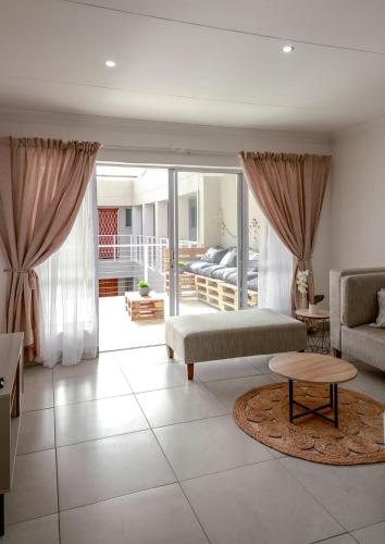 a living room with a couch and a table at Neptunes Hideaway in Jeffreys Bay
