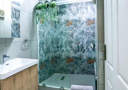 a bathroom with a shower with a glass door at Neptunes Hideaway in Jeffreys Bay