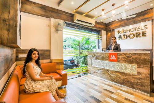 a woman sitting in a waiting room at a restaurant at FabExpress Adore Inn - Nr Mumbai International Airport in Mumbai