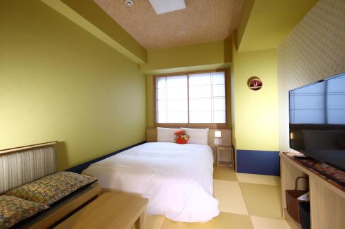 a bedroom with a bed and a flat screen tv at Onyado Nono Osaka Yodoyabashi in Osaka
