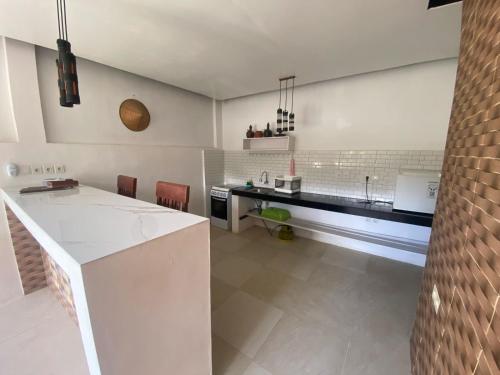 a white kitchen with a counter and a sink at bali amed feel home in Amed