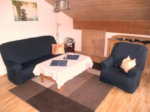 a living room with two chairs and a table at Dachgeschosswohnung Mit Toller Aussicht Vom Balkon in Bayersoien