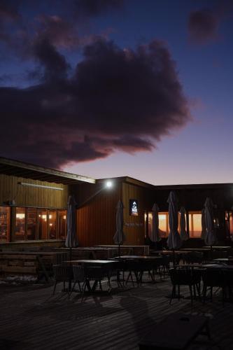 a building with tables and umbrellas at night at Le Mont in Almaty