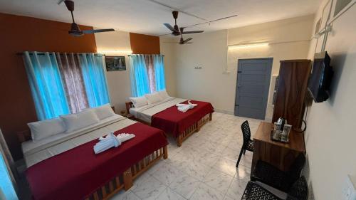 a hotel room with two beds and a television at Moonlight Residency in Kollam
