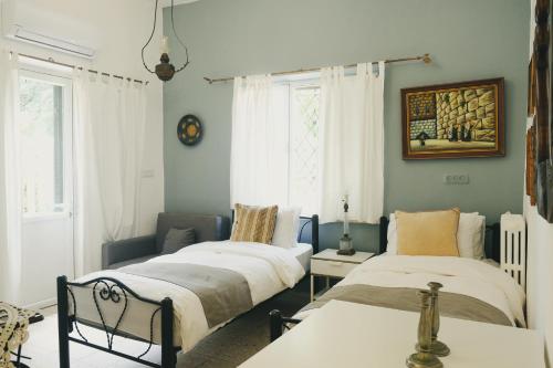 a bedroom with two beds and a couch at Tzefania Hotel in Jerusalem