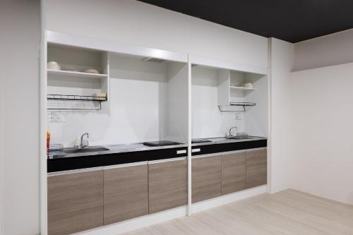 a kitchen with two sinks and two counters at Huntelia Matsuyama in Matsuyama