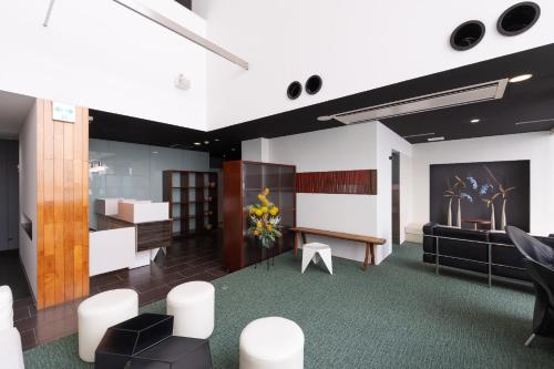 a lobby with a waiting room with a table and chairs at Huntelia Matsuyama in Matsuyama