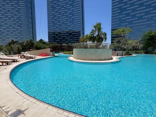 a large swimming pool in a city with tall buildings at HighFloor 3BR plus Maids GateTower in Abu Dhabi