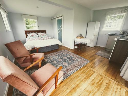 a small room with a bed and a kitchen at Peaceful private and semi rural in Marton