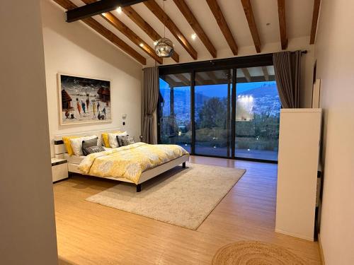 une chambre avec un lit et une grande fenêtre dans l'établissement Villa VH 4 Bedroom villa with heated swimming pool, à Kigali