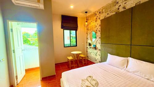 a bedroom with a bed and a door to a balcony at Cozy Bay Rawai in Phuket Town