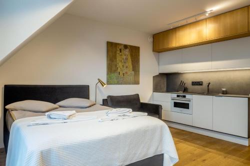 a bedroom with a bed and a kitchen at Laimes kopa Pervalka in Pervalka