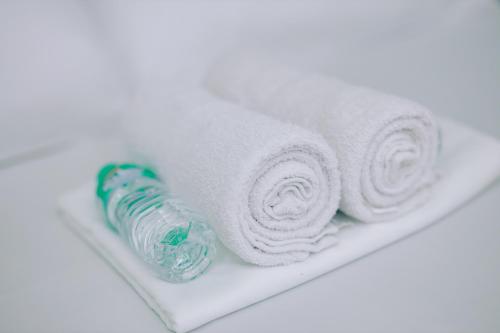 a stack of towels and a bottle on a shelf at RedDoorz near Mariners Legazpi in Legazpi