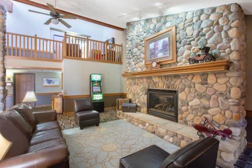 ein Wohnzimmer mit einem Steinkamin und einem Sofa in der Unterkunft AmericInn by Wyndham Lincoln North in Lincoln
