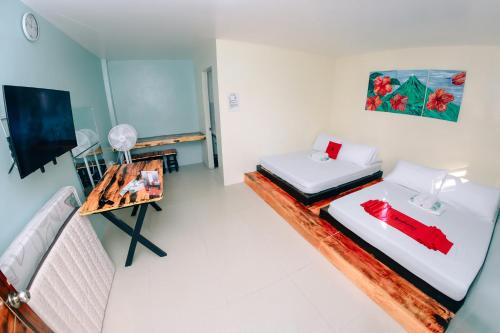 a small room with two beds and a table at RedDoorz near Mariners Legazpi in Legazpi
