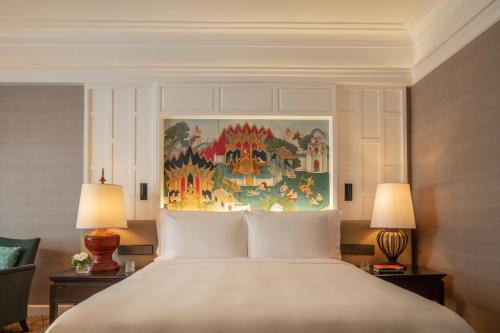 a bedroom with a large white bed with two lamps at Anantara Siam Bangkok Hotel in Bangkok