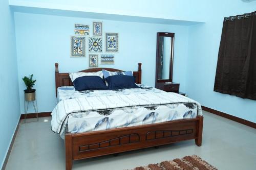 Un dormitorio con una cama en una habitación azul. en Deepam Haven Inn, en Gūduvāncheri