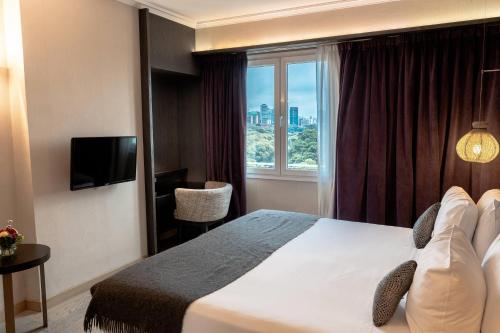 een hotelkamer met een bed en een raam bij Esplendor Plaza Francia in Buenos Aires