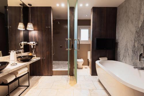 een badkamer met een bad, een toilet en een douche bij Esplendor Plaza Francia in Buenos Aires