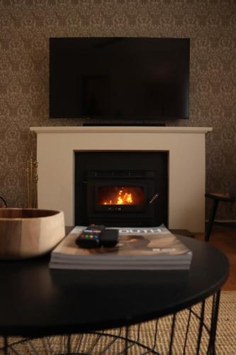 a living room with a fire in a fireplace at Vale & Vine in McLaren Vale
