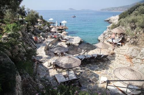 a beach with chairs and umbrellas and the ocean at Soothe Hotel in Kalkan