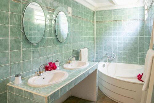 La salle de bains est pourvue de 2 lavabos, d'une baignoire et de miroirs. dans l'établissement PROMO NOËL ! CASA LYDIE 3 Ch Premium Piscine Privée, à Saint-François