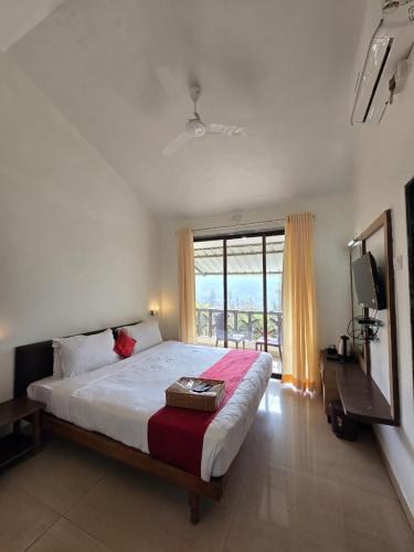 a bedroom with a large bed and a large window at Cloud Green Resort in Mahabaleshwar
