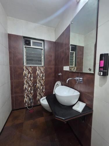 a bathroom with a sink and a toilet in it at Cloud Green Resort in Mahabaleshwar