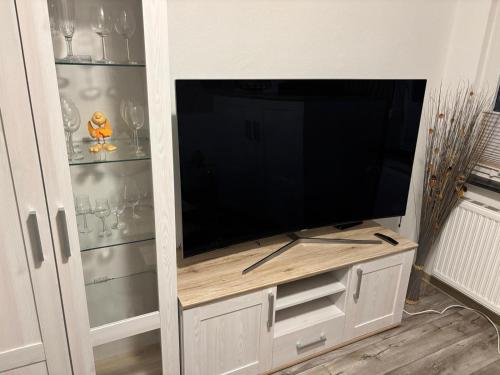 a entertainment center with a large flat screen tv at FeWo Papenburg im OG - Nähe City in Papenburg