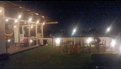 a group of tables and chairs on a patio at night at Rusha Stays in Gumgaon