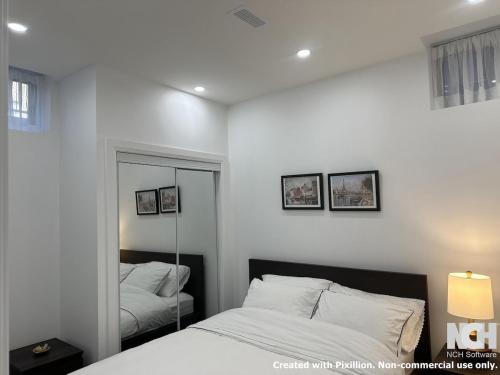 - une chambre blanche avec un miroir et un lit dans l'établissement Modern 2-Bedroom Apartment in Luxury Home with Gym, à Colline De Richmond