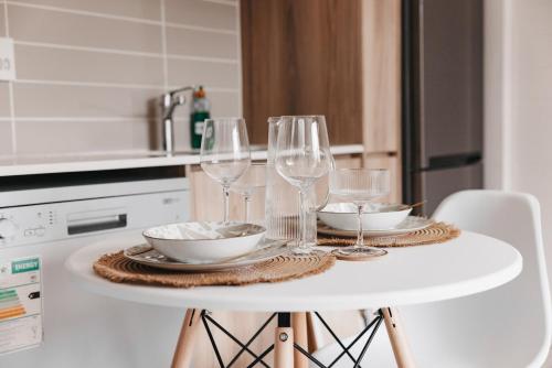 a white table with wine glasses and bowls on it at Casa de Lior!- Luxury apartment in Sandton