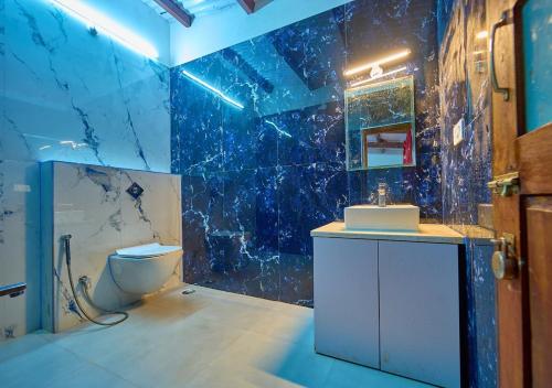 乌提Shivvs Heritage Resort Ooty的一间带卫生间的浴室和蓝色瓷砖墙