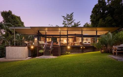a large glass house with a lawn in front of it at Crystal Creek Rainforest Retreat in Crystal Creek