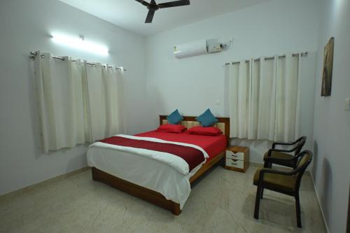 a bedroom with a bed and a chair in it at Prashanthi Nature View - Luxury 2Bhk Villa in Udupi
