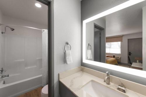 Un baño con lavabo y un espejo grande. en Super 8 by Wyndham Fort Bragg, en Fort Bragg