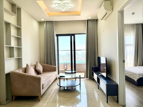 a living room with a couch and a tv and a bed at Monarchy Luxury Serviced Apartments - By Charm Homestay Vietnam in Da Nang