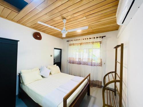 a bedroom with a bed and a wooden ceiling at Villa Climax in Ahangama