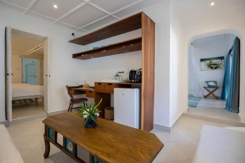 Una cocina y una sala de estar con refrigerador y una mesa. en Nomad Beach Resort, en Diani Beach