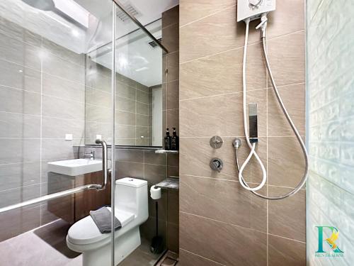 een badkamer met douche, toilet en wastafel bij Grand Medini Suites by RR JBcity in Nusajaya