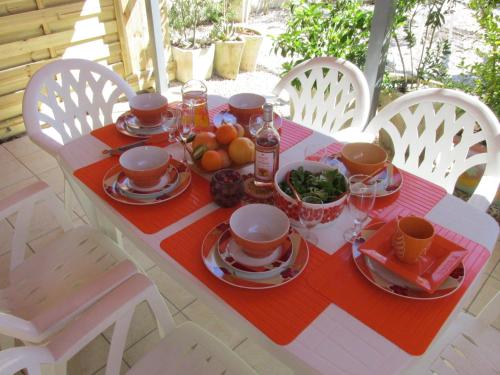 une table avec des assiettes de nourriture au-dessus dans l'établissement Villa Relax de plain pied - Marseillan, à Marseillan