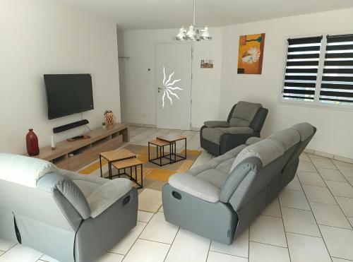 een woonkamer met twee banken en een flatscreen-tv bij L'Estran qu'Île - Proche plages in LʼÎle-dʼOlonne