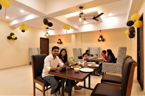 een groep mensen die aan een tafel in een restaurant zitten bij FabHotel Blueark in Lucknow
