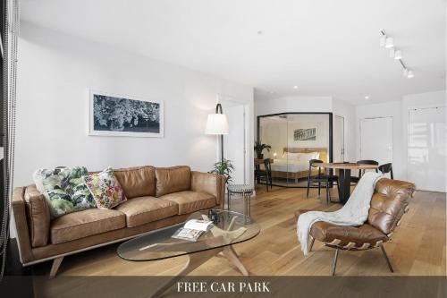 a living room with a couch and a table at Sleek City Flat, 5-Star Location with Free Parking in Melbourne